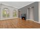 Bright living room featuring large arched windows, wood floors, and a cozy fireplace at 2121 Whitekirk Nw St, Kennesaw, GA 30152