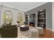 Bright staged living room featuring arched windows, wood floors, fireplace, and modern furniture at 2121 Whitekirk Nw St, Kennesaw, GA 30152