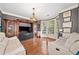Cozy living room with hardwood floors, natural light from the large windows, and custom built-in entertainment center at 2121 Whitekirk Nw St, Kennesaw, GA 30152