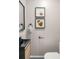 Modern powder room with black sink, fixtures, light wood cabinet, and framed art at 3069 Thrasher Cir, Decatur, GA 30032
