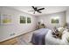 Bedroom with hardwood floors, modern fan, two windows, decorative pillows, and neutral paint at 3069 Thrasher Cir, Decatur, GA 30032