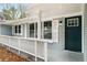 Welcoming entrance with white railing, a dark teal front door, white shutters, and painted brick at 3069 Thrasher Cir, Decatur, GA 30032