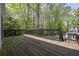 Large wooden back deck with black railings overlooks a lush backyard surrounded by trees at 7037 Waters Edge Dr, Stone Mountain, GA 30087