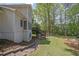 Backyard view showing a well-manicured lawn, stone landscaping, and mature trees at 7037 Waters Edge Dr, Stone Mountain, GA 30087
