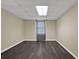 Basement area featuring laminate floors, neutral walls and trim, and a window with a checked valance for privacy at 7037 Waters Edge Dr, Stone Mountain, GA 30087