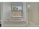 A luxurious bathroom features a soaking tub, shower, and a bright window with pleasant views at 7037 Waters Edge Dr, Stone Mountain, GA 30087