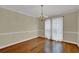 Charming dining room featuring hardwood floors, classic chandelier, and large windows with natural light at 7037 Waters Edge Dr, Stone Mountain, GA 30087