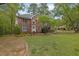 Two-story brick home with a well-manicured front lawn and mature trees, offering great curb appeal at 7037 Waters Edge Dr, Stone Mountain, GA 30087