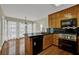 Spacious kitchen featuring stainless steel appliances, black countertops, and wood cabinets at 7037 Waters Edge Dr, Stone Mountain, GA 30087