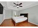 Spacious main bedroom features tray ceiling, wood floors, ceiling fan, and a TV at 7037 Waters Edge Dr, Stone Mountain, GA 30087