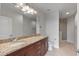 Bathroom featuring granite counters, double sinks, a large mirror and a glass enclosed shower at 855 Peachtree Ne St # 2403, Atlanta, GA 30308