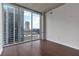 Bedroom featuring hardwood floors and a large window offering views of the city skyline at 855 Peachtree Ne St # 2403, Atlanta, GA 30308