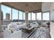 Bright living room with city view, white furniture and hardwood floors at 855 Peachtree Ne St # 2403, Atlanta, GA 30308