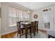 Bright dining area with a square table, hardwood floors, and ample natural light from a large window at 3967 Bellingrath Main Nw, Kennesaw, GA 30144