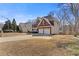 Brick home with a two-car garage has mature trees in the yard on a sunny day at 3967 Bellingrath Main Nw, Kennesaw, GA 30144