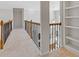 Upstairs hallway with carpeted floors, a bookshelf, and iron railing at 3967 Bellingrath Main Nw, Kennesaw, GA 30144