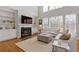 Open-concept living room featuring built-ins, fireplace, large windows, and hardwood floors at 3967 Bellingrath Main Nw, Kennesaw, GA 30144