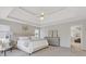 Spacious primary bedroom featuring a tray ceiling, ceiling fan, and sitting area at 3967 Bellingrath Main Nw, Kennesaw, GA 30144