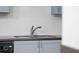 Close up of kitchen sink with chrome faucet, white tile backsplash and blue cabinets at 400 17Th Nw St # 2218, Atlanta, GA 30363