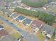 An aerial view of a house with a gray roof, patio, and fenced-in backyard in a neighborhood with surrounding homes and trees at 4349 Sublime Trl, Atlanta, GA 30349