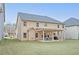A backyard with an entertainment space and exterior view of a 2-story home with gray roof and light-colored siding at 4349 Sublime Trl, Atlanta, GA 30349