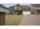 A charming two-story brick home featuring a covered front porch, front yard, long driveway, and a two-car garage at 4349 Sublime Trl, Atlanta, GA 30349