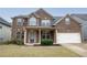 A charming two-story brick home featuring a covered front porch and well-maintained landscaping at 4349 Sublime Trl, Atlanta, GA 30349