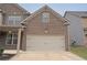 Attached two-car garage with a brick exterior and complementary architectural details at 4349 Sublime Trl, Atlanta, GA 30349
