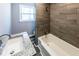 Stylishly updated bathroom features a tub with a modern tiled shower and granite counters at 6727 Kull Dr, Lithia Springs, GA 30122