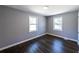 Bright bedroom with hardwood floors, two large windows, and freshly painted walls at 6727 Kull Dr, Lithia Springs, GA 30122