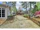 Landscaped backyard featuring stone walkways, mature trees, and a patio with outdoor seating at 803 Amerden Ponds Ct, Johns Creek, GA 30097