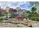 The house sits on beautifully landscaped grounds with lush greenery and a serene pond at 803 Amerden Ponds Ct, Johns Creek, GA 30097