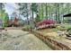 Landscaped backyard featuring stone walkways, mature trees, and a patio with outdoor seating at 803 Amerden Ponds Ct, Johns Creek, GA 30097