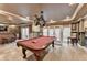 Finished basement area with a pool table, bar with barstools, stacked stone wall, and recessed lighting at 803 Amerden Ponds Ct, Johns Creek, GA 30097