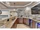 Finished basement bar featuring granite countertops, custom cabinets, wine refrigerator, and tile floors at 803 Amerden Ponds Ct, Johns Creek, GA 30097