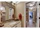 Charming bathroom featuring granite countertops, white cabinetry, decorative mirror, and elegant lighting at 803 Amerden Ponds Ct, Johns Creek, GA 30097