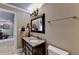Bright bathroom features granite countertops, black cabinetry, decorative mirror, and elegant lighting at 803 Amerden Ponds Ct, Johns Creek, GA 30097