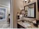 Bright bathroom features granite countertops, black cabinetry, decorative mirror, and elegant lighting at 803 Amerden Ponds Ct, Johns Creek, GA 30097