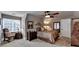 Comfortable bedroom with neutral carpet, ceiling fan, comfortable furniture, and a well lit space at 803 Amerden Ponds Ct, Johns Creek, GA 30097