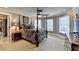 Large bedroom featuring a four-poster bed, multiple windows, and carpet flooring at 803 Amerden Ponds Ct, Johns Creek, GA 30097