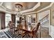 Elegant dining room with chandelier, tray ceiling, and large windows providing natural light for formal dinners at 803 Amerden Ponds Ct, Johns Creek, GA 30097