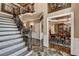 Grand foyer featuring a staircase with iron railings and marble flooring that leads to an open dining room at 803 Amerden Ponds Ct, Johns Creek, GA 30097