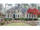 Stately two-story home with a manicured front lawn, tasteful landscaping, and an elegant facade at 803 Amerden Ponds Ct, Johns Creek, GA 30097