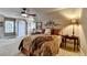 Comfortable bedroom featuring a ceiling fan, wall decorations, and a decorative brown patterned bed spread at 803 Amerden Ponds Ct, Johns Creek, GA 30097