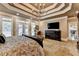 Luxurious main bedroom showcasing a large bed, tray ceilings and a flat-screen television at 803 Amerden Ponds Ct, Johns Creek, GA 30097