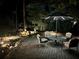 Night shot of backyard waterfall feature and patio under illuminated umbrella at 803 Amerden Ponds Ct, Johns Creek, GA 30097