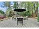 Seating area featuring a stone patio with an umbrella-covered table surrounded by chairs at 803 Amerden Ponds Ct, Johns Creek, GA 30097