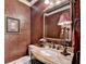 Elegant powder room featuring decorative wallpaper, granite countertop, ornate mirror, and stylish fixtures at 803 Amerden Ponds Ct, Johns Creek, GA 30097