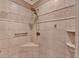 Walk-in shower featuring a rainfall shower head, corner seat, and tiled walls with decorative accents at 803 Amerden Ponds Ct, Johns Creek, GA 30097