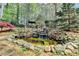 Relaxing backyard waterfall feature flowing into a pond surrounded by rocks and lush landscaping at 803 Amerden Ponds Ct, Johns Creek, GA 30097
